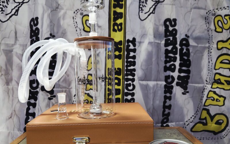 A glass water pipe and case on display.